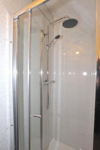 a shower with a glass door in a bathroom at California Inn in Brynteg