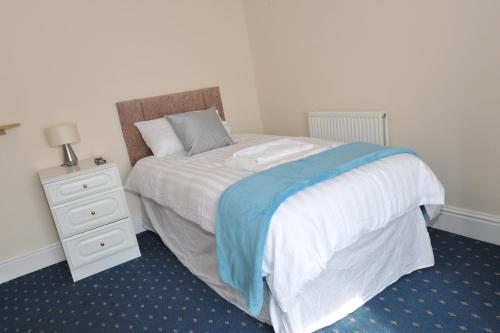 a bedroom with a bed with a nightstand and a bed sidx sidx sidx sidx at California Inn in Brynteg