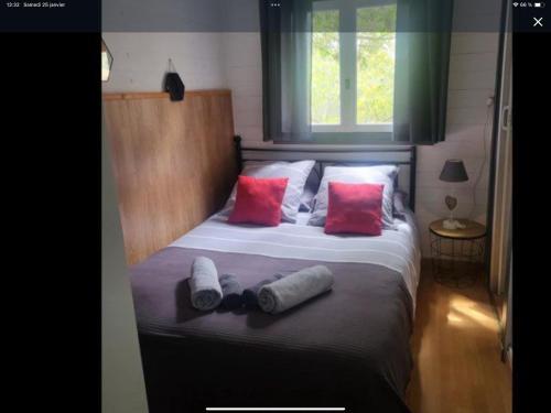 a bedroom with a bed with red and white pillows at chalet Bati in Bonifacio