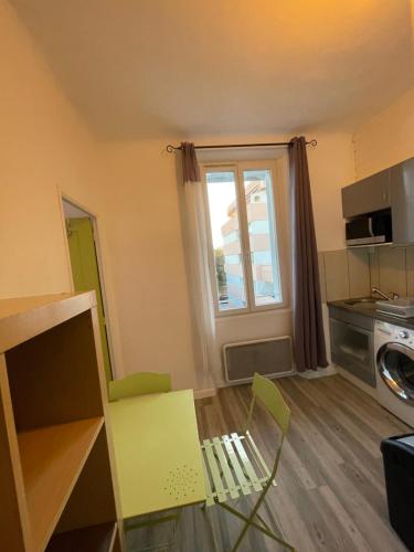 - un salon avec une chaise verte et une fenêtre dans l'établissement Petit nid, à Saint-Raphaël