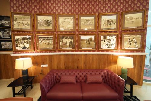 a couch in a room with pictures on the wall at Mayfair World Cup Village in Rourkela