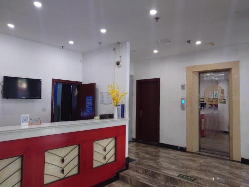 a lobby with a red and white counter and a door at GreenTree Inn Shell Hotel Shanghai Waigaoqiao Free Trade Zone North Subway Station Branch in Shanghai
