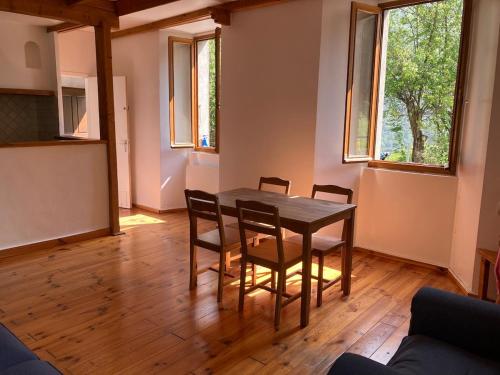 une salle à manger avec une table et quatre chaises dans l'établissement Confortable logement au coeur des montagnes, au Lauzet-Ubaye