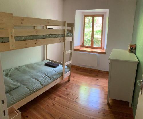 une chambre avec deux lits superposés et un bureau dans l'établissement Confortable logement au coeur des montagnes, au Lauzet-Ubaye