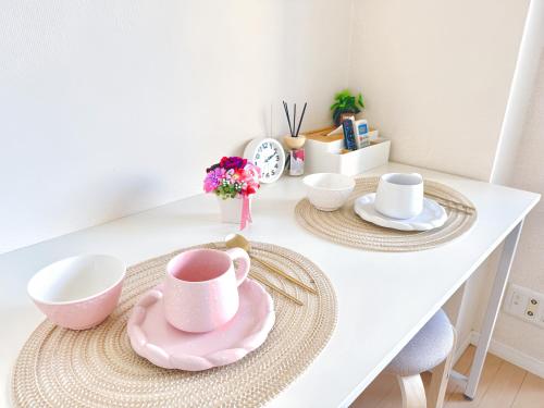 a white table with a pink tea set on it at 錦糸町-601 in Tokyo