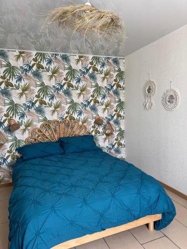 - une chambre avec un lit bleu et un papier peint tropical dans l'établissement Chez Sylviane Rez-de-Chaussée 200 m de la mer, à Luc-sur-Mer