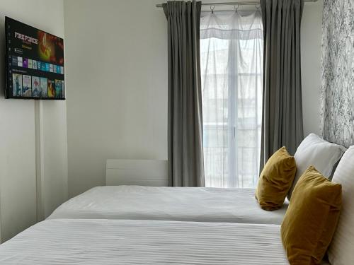 a bedroom with a bed with yellow pillows and a window at Appt Vue Place de Toscane - 4min Disneyland-PARIS in Serris