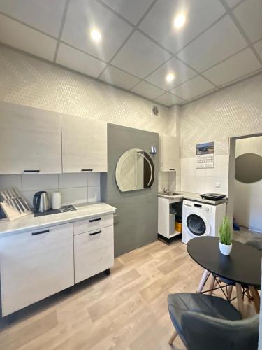a kitchen with white cabinets and a table and a sink at KunK in Ventspils