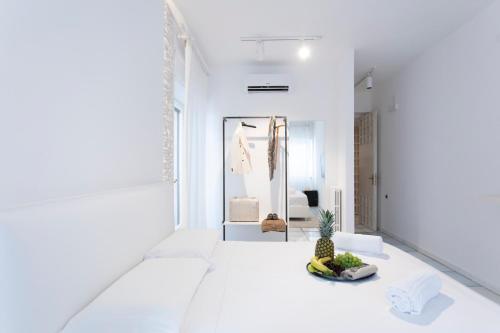 Habitación blanca con un bol de fruta en el suelo en Bocà Home - Intero appartamento, en Salerno