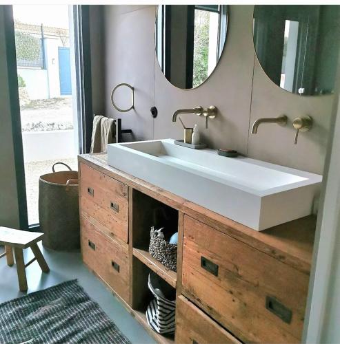 une salle de bain avec un lavabo et un grand miroir dans l'établissement La maison du bonheur, à Saint-Siffret