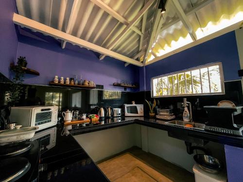 una cucina con pareti viola e piano di lavoro di Coconut Beach House a Galle