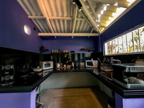 una cucina con pareti viola e piano di lavoro di Coconut Beach House a Galle