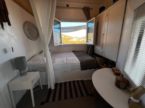 a small bedroom with a bed and a window at Antiparos Private House Agios Georgios in Antiparos