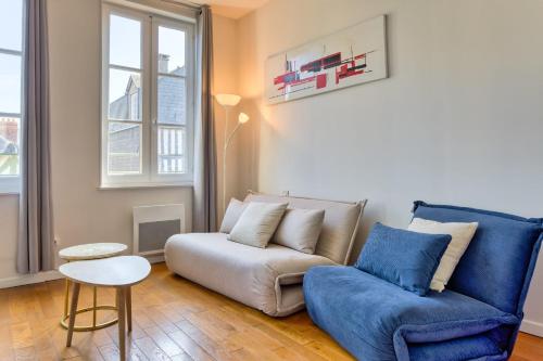 un salon avec un canapé et une chaise bleue dans l'établissement Petit Castel - charmant T2 de 39m au cœur de Rouen Rue du Gros-Horloge !, à Rouen