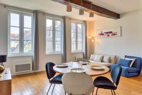 un salon avec une table, des chaises et un canapé dans l'établissement Petit Castel - charmant T2 de 39m au cœur de Rouen Rue du Gros-Horloge !, à Rouen