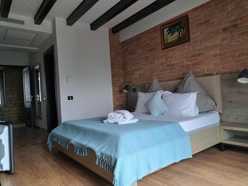 a bedroom with a bed with a brick wall at Valahia in Dunavăţu de Jos