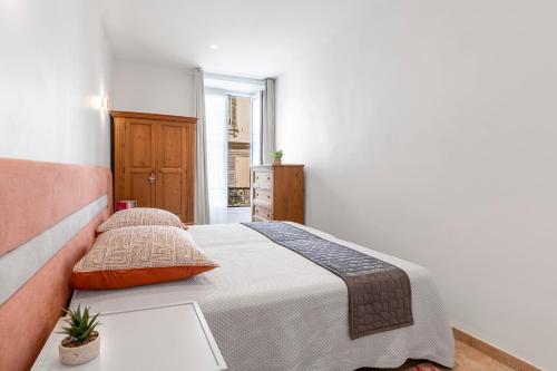 une chambre avec un lit dans une pièce blanche dans l'établissement Appartement 2 chambres proche plage climatisé, à Nice