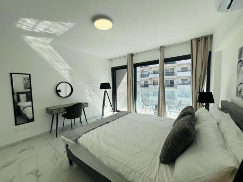 a white bedroom with a large bed and a desk at Nicosia City Centre City Vibes Luxury 1BD in Nicosia