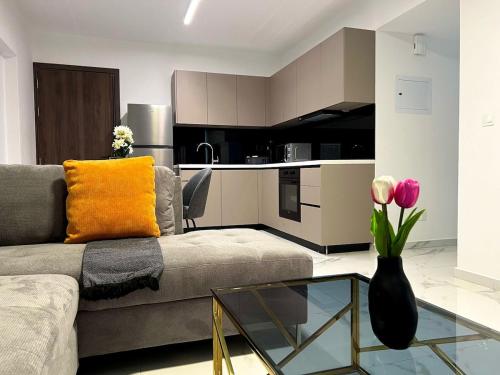 a living room with a couch and a vase with flowers at Nicosia City Centre City Vibes Luxury 1BD in Nicosia