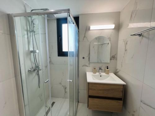 a bathroom with a glass shower and a sink at Nicosia City Centre City Vibes Luxury 1BD in Nicosia