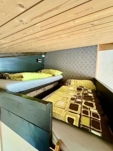 two bunk beds in a room with wooden ceilings at Ferienwohnung Brunni-Lodge am Grossen Mythen in Alpthal
