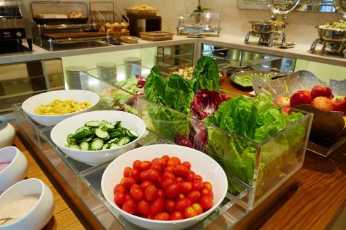 a buffet with bowls of vegetables on a counter at Taipei Fullerton Hotel-Maison North in Taipei