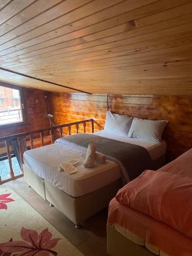 a bedroom with two beds and a wooden ceiling at Ayder Villas in Çamlıhemşin