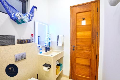 a bathroom with a sink and a wooden door at Diani Beachfront Villa Amani at Diani in Ukunda