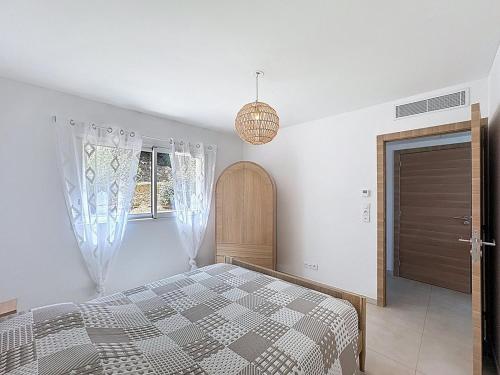 une chambre blanche avec un lit et une fenêtre dans l'établissement Appartement avec vue sur la mer et la citadelle, à Calvi