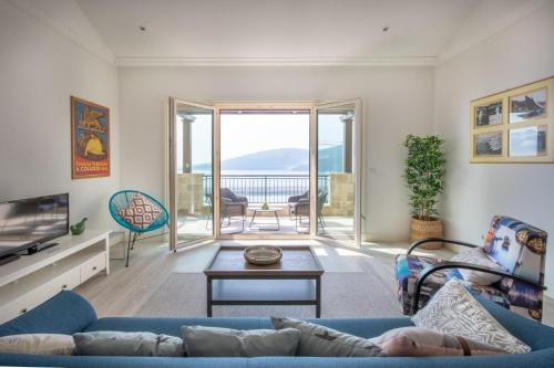 a living room with a blue couch and a balcony at Lustica Bay Marina Village by 2BHome in Lustica