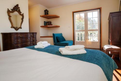 a bedroom with a bed and a blue chair at VILLA CATARINA · XuresVillas in Lobios