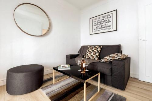 - un salon avec une chaise noire et un miroir dans l'établissement T2 Bonaparte Place du Pin Port Nice, à Nice