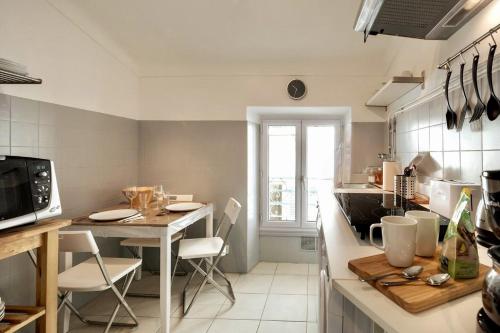 - une cuisine avec une table, une table et des chaises dans l'établissement T2 Bonaparte Place du Pin Port Nice, à Nice