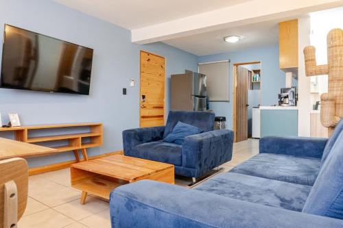 a living room with two blue chairs and a tv at Marina AZUL To live La Paz in La Paz