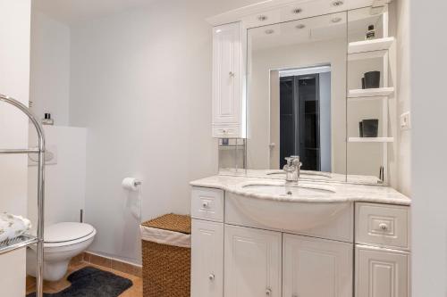une salle de bain blanche avec un lavabo et des toilettes dans l'établissement Appartement 2 chambres proche plage climatisé, à Nice