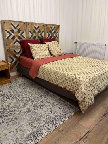 une chambre avec un grand lit avec des oreillers dessus dans l'établissement Balnéo Jardins d'Eloïse à Toulouse, à Toulouse