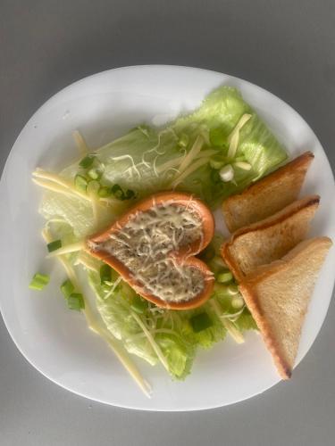 a plate of food with lettuce and vegetables and bread at Súkromný relax pre dvoch Špačince in Špačince
