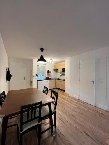 une cuisine et une salle à manger avec une table et des chaises dans l'établissement Balnéo Jardins d'Eloïse à Toulouse, à Toulouse