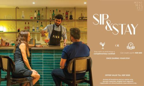 un uomo e una donna seduti al bar con un barista di Minimalist One Hauz Khas Village a Nuova Delhi