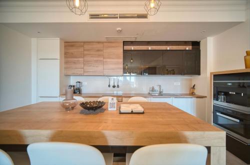 a kitchen with a large wooden table with chairs at Lustica Bay Marina Village by 2BHome in Lustica