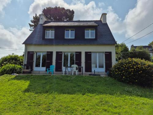 une maison avec deux chaises et une table dans la cour dans l'établissement Maison familiale Morgat, jardin clos, à Crozon