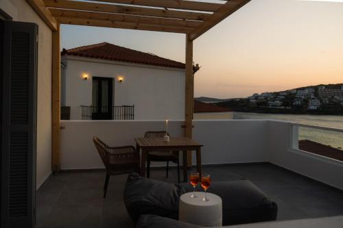 a patio with a table and chairs on a balcony at Noleya Pure Island Stay in Batsi