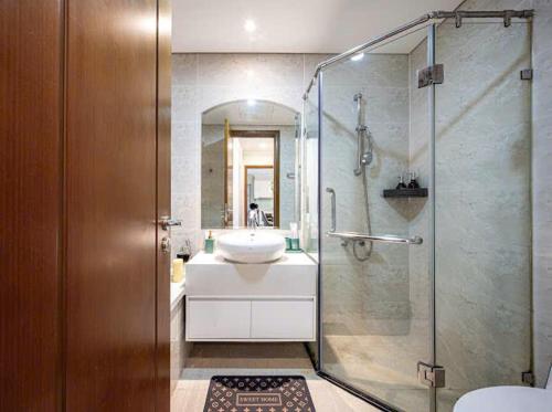 a bathroom with a glass shower and a sink at LUNA Apartment - Luxury Residence Landmark 81 Area in Ho Chi Minh City