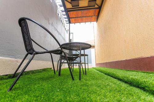 two chairs and a table in a room with grass at The Den Soroti Green in Soroti