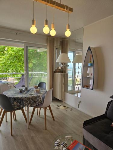 un salon avec une table et des chaises et une salle à manger dans l'établissement Lagrange Vacances Les Résidences du Bassin, à Arcachon