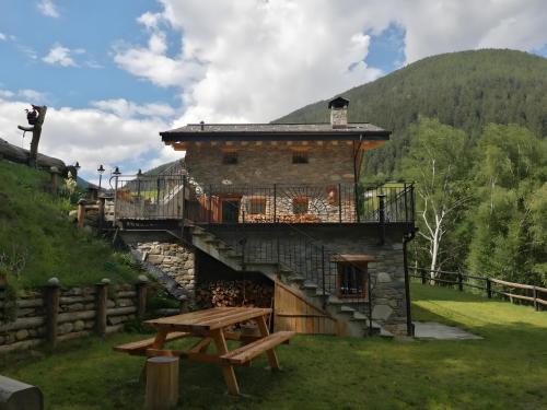 a building with a picnic table in front of it at Chalet Cuore Selvatico in Monno