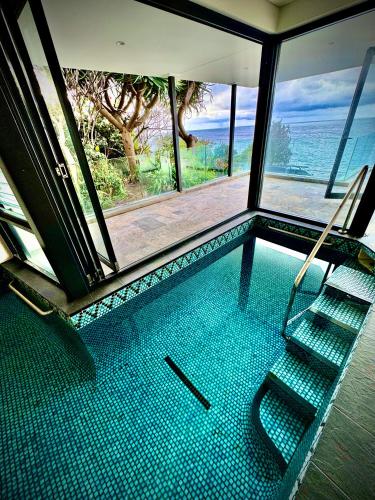 a swimming pool with a view of the ocean at Ocean view home South Coogee in Sydney