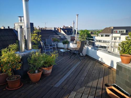 a deck with plants and chairs on a balcony at Centrally located spacious flat close to Rhine in Bonn