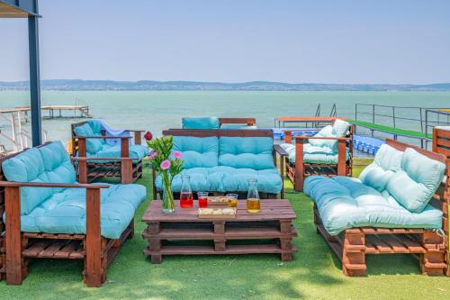 a group of chairs and couches on a deck at Villa My Lake in Zamárdi