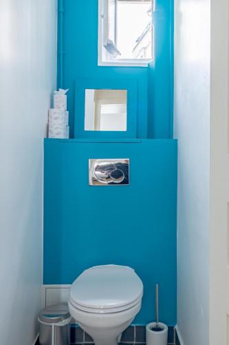 La salle de bains bleue est pourvue de toilettes et d'une fenêtre. dans l'établissement Montmartre Heaven 1 Bed 4 PPL, à Paris